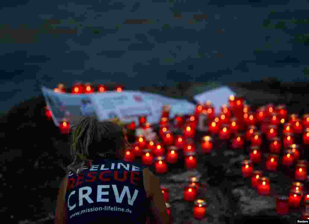 A crew member of charity ship MV Lifeline takes part in a vigil to commemorate migrants who have lost their lives whilst crossing the Mediterranean Sea, and to insist that such loss of life is never normalised in light of some European governments enactin