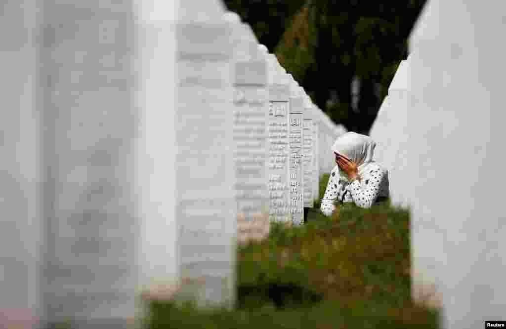 A woman cries at a graveyard, ahead of a mass funeral in Potocari near Srebrenica, Bosnia and Herzegovina, July 11, 2020. Bosnia marks the 25th anniversary of the massacre of more than 8,000 Bosnian Muslim men and boys, with many relatives unable to attend due to the COVID-19 outbreak. 