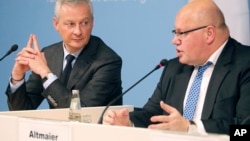 German Economy Minister Peter Altmaier, right, and France's Economy Minister Bruno Le Maire, left, address the media during a joint statement in Berlin, Germany, Feb. 19, 2019. (W. Kumm/dpa via AP) 