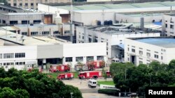 Firefighter trucks are seen next to a damaged building after an explosion at a factory in Zhoushan, Jiangsu province, China, Aug. 2, 2014. 