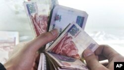 FILE — A man counts Egyptian currency at an exchange office in Cairo, on March 14, 2016.