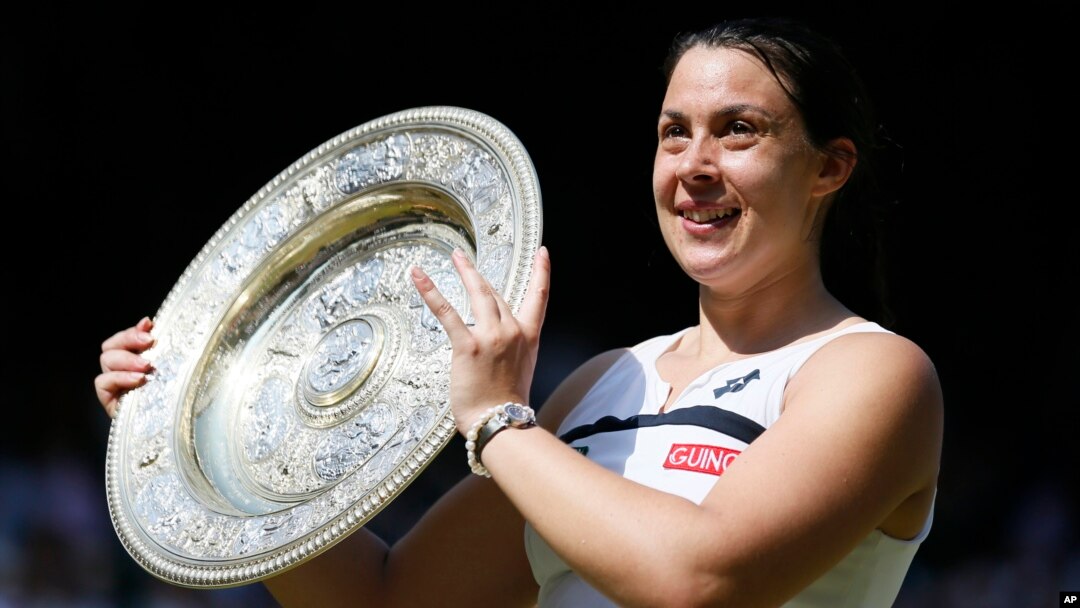 Marion Bartoli dari Perancis berpose dengan trofi kejuaraan Wimbledon setelah mengalahkan Sabine Lisicki dari Germany dalam final putri di London (6/7). (AP/Stefan Wermuth)