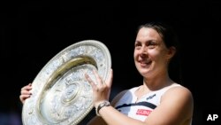 Fransèz Marion Bartoli avèk twofe a nan men l aprè viktwa li an final sou almand Sabine Lisicki nan Wimbledon, London (6 jiyè 2013).