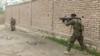 A member of Afghan security forces fires towards Taliban positions on a street in Kunduz, Afghanistan, Aug. 31, 2019, in a still image taken from video.