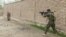 A member of Afghan security forces fires towards Taliban positions on a street in Kunduz, Afghanistan, Aug. 31, 2019, in a still image taken from video.