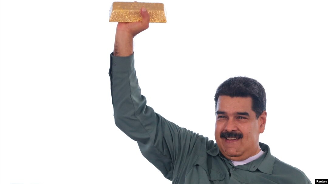 Tổng thống Venezuela Nicolas Maduro cầm một thỏi vàng trong khi gặp gỡ các đại diện của ngành khai khoáng năm 2017.