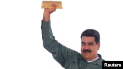 Tổng thống Venezuela Nicolas Maduro cầm một thỏi vàng trong khi gặp gỡ các đại diện của ngành khai khoáng năm 2017.