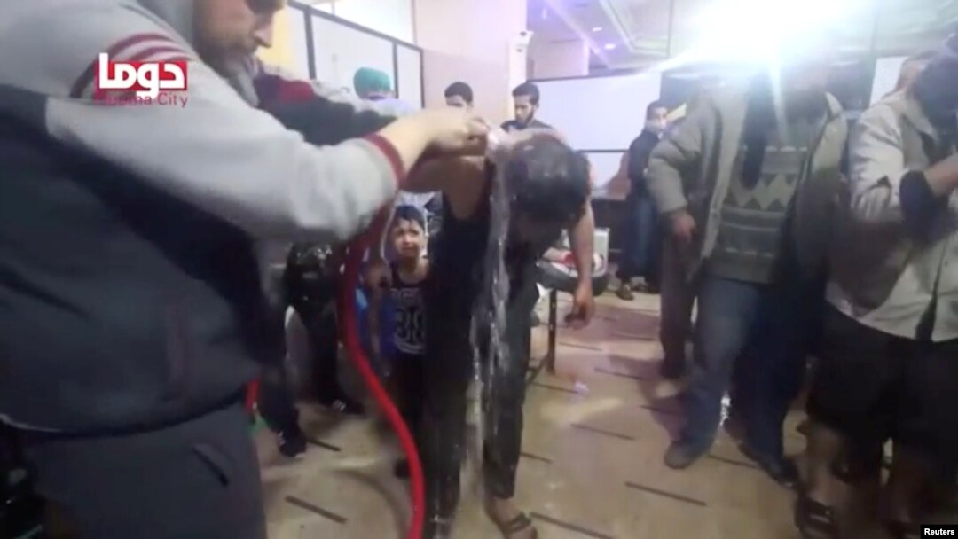 Seorang pria disemprot air setelah terkena serangan yang diperkirakan senjata kimia di kawasan Douma, Suriah, dari video yang diperoleh oleh Reuters, 8 April 2018. (White Helmets / Reuters TV)
