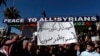 FILE - Syrian Druze hold up a placard in Arabic which reads "Sweida will not be your poisoned dagger in Syria's back" and stage a demonstration against Israeli incursions into Syrian territory in the southern province of Sweida, Syria, Feb. 25, 2025.