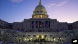 FILE - The sun rises behind the U.S. Capitol in Washington, Jan. 12, 2025. Because temperatures are expected to dip below freezing on Monday, President-elect Donald Trump is moving his swearing-in ceremony from outside to inside the U.S. Capitol.