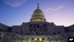 FILE - The sun rises behind the U.S. Capitol as a rehearsal begins on the West Front ahead of President-elect Donald Trump's upcoming inauguration in Washington, Jan. 12, 2025.