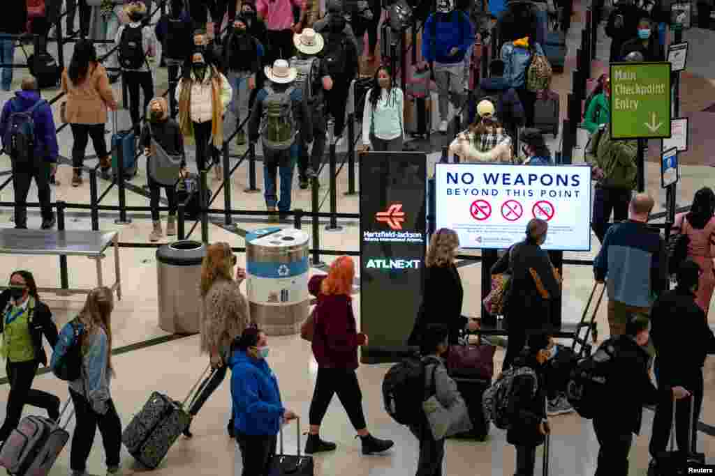 Travelers form lines outside the TSA security checkpoint during the holiday season, as the coronavirus Omicron variant threatens to increase case numbers, at Hartsfield-Jackson Atlanta International Airport in Atlanta, Georgia, Dec. 22, 2021.