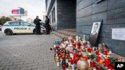 FILE - Police guard the entrance to the offices of news website Aktuality, the employer of murdered investigative journalist Jan Kuciak, in Bratislava, Slovakia, February 27, 2018. Peter Sabo, another Aktuality reporter, found a bullet in his mailbox.