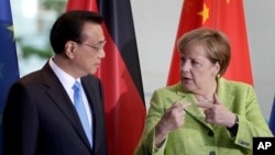 German Chancellor Angela Merkel, right, and China's Premier, Li Keqiang, left, talk during a contract signing ceremony as part of a meeting at the chancellery in Berlin, June 1, 2017.