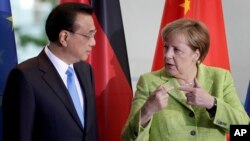 German Chancellor Angela Merkel, right, and China's Premier, Li Keqiang, left, talk during a contract signing ceremony as part of a meeting at the chancellery in Berlin, June 1, 2017.