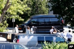 Reporters watch as Democratic presidential candidate Hillary Clinton's van leaves a FBI facility in White Plains, New York, after she received her first classified intelligence briefing as a leading presidential contender, Aug. 27, 2016.