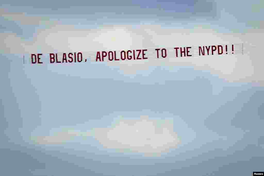A banner reading &quot;de Blasio, apologize to the NYPD&quot; towed by an airplane flies over the Hudson River in New York, Dec. 31, 2014. Police union leaders said their grievances with New York City Mayor Bill de Blasio remained unresolved after meeting with him, 10 days after they said he was partly to blame for a gunman&#39;s deadly attack on two policemen.