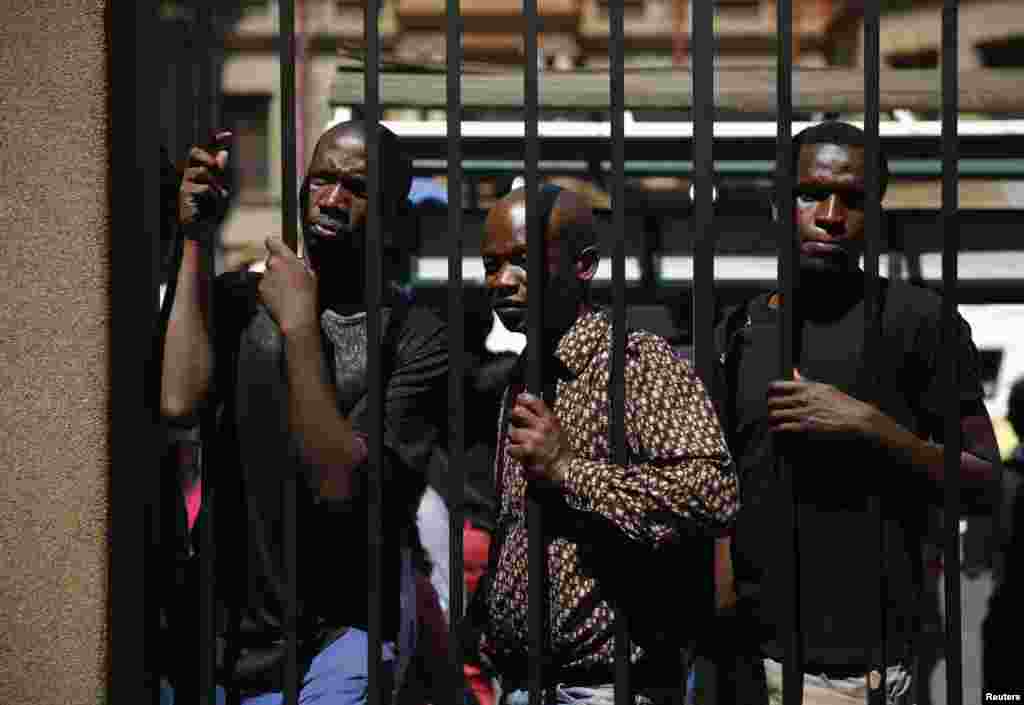 Onlookers attempt to catch a glimpse of Oscar Pistorius as he leaves the court, Sept. 12, 2014. 