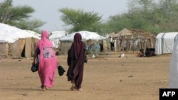 Des femmes maliennes marchent dans le camp de réfugiés de Goudebou au Burkina Faso, 26 juillet 2013. PHOTO AFP / AHMED OUOBA / PHOTO AFP / AHMED OUOBA