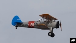 FILE - Archbishop Gregory Aymond rides in a World War II era Stearman PT-17 biplane over the city of New Orleans, April 10, 2020.