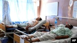 FILE - Wounded Afghans lie on beds at a hospital after a bomb attack on election day in Kandahar province, south of Kabul, Afghanistan, Sept. 28, 2019.