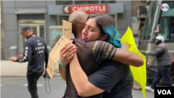 Manifestantes se abrazan en una protesta en Washington, Minnesota, no llevan máscaras y no guardan una distancia social apropiada de protección contra el coronavirus. [Foto: Ronec Suarc, VOA]