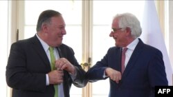 US Secretary of State Mike Pompeo, left, and Polish Foreign Minister Jacek Czaputowicz greet each other with an elbow bump as they meet in Lazienki palace in Warsaw, Poland,