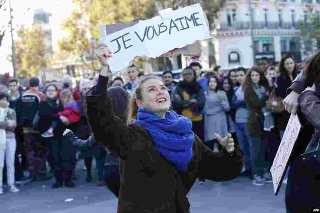 A woman holds a sign reading &#39;I love you&#39; as people gather at the Place de la Republique in Paris, on Nov. 15, 2015, two days after a series of deadly attacks.