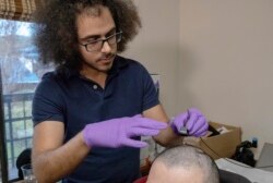 In this 2020 photo provided by the University of California, San Francisco, researcher David Moses works with clinical trial participant "BRAVO 1" to record brain activity while he attempted to produce words and sentences.