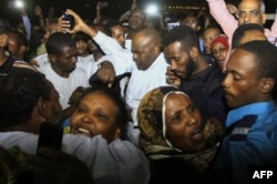 FILE - Family members welcome their loved ones after Sudan released dozens of opposition activists who were arrested last month when authorities cracked down on protests against rising food prices, outside the Kobar prison in north Khartoum on Feb. 18, 20