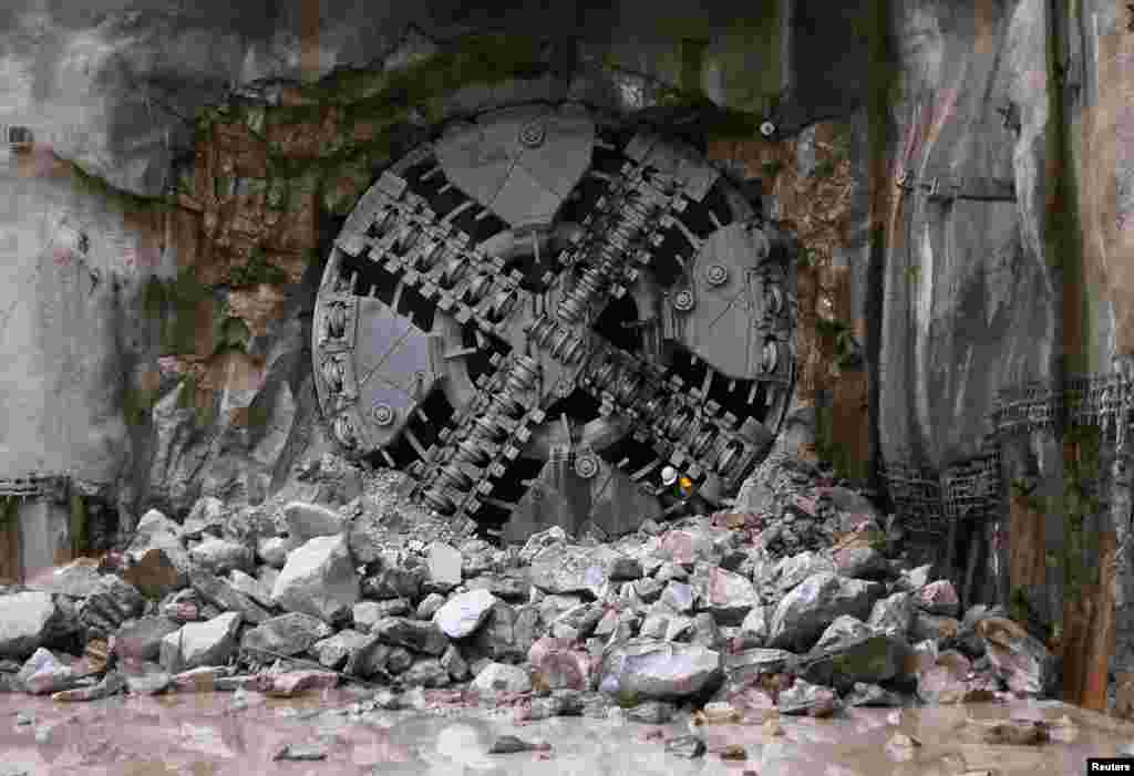 An engineer crawls through a hole in a Tunnel Boring Machine (TBM) during the breakthrough of a tunnel in Kuala Lumpur, Malaysia. The world&#39;s first variable density TBM has completed the first section of the 9.5 km (5 miles) twin tunnels of the Klang Valley MRT (Mass Rapid Transit) line.