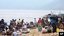 People gather at a market on July 21, 2011 on the banks of the Congo River near the village of Ngamanzo in the municipality of Maluku, Kinshasa province, an area under surveillance by medical officials for signs of cholera.