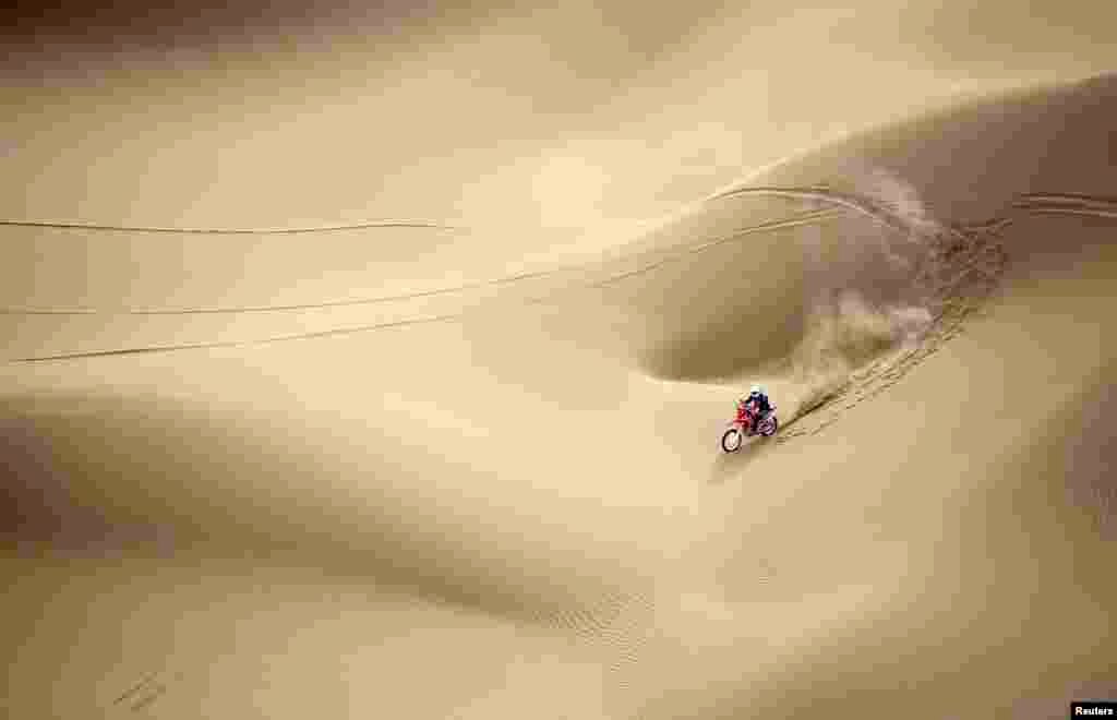 Wang Yirong of Hebei province rides his motorcycle in a desert during the China Taklimakan Rally and CCR Xinjiang Station, in Shanshan, Xinjiang Uighur Autonomous Region, May 31, 2014.