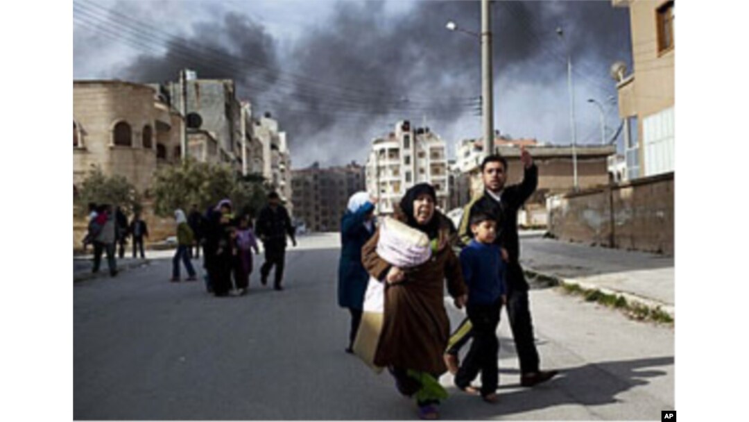A family escapes from fierce fighting between Free Syrian Army fighters and government troops in Idlib, north Syria, March 10, 2012.
