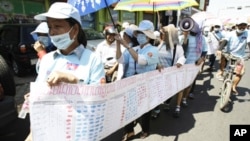 In this photo taken on Friday, May 4, 2012, Cambodian protesters from Boueng Kak lake march with a banner displaying the thumb prints of fellow land owners who have been evicted from their homes, as they demand compensation, in Phnom Penh, file photo. 