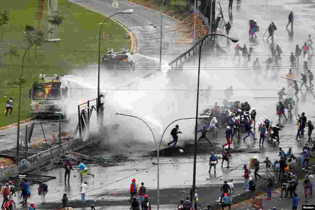 베네수엘라 수도 카라카스에서 반정부 시위대가 공군부대에 접근하자, 경찰이 물대포를 쏴서 밀어내고 있다.