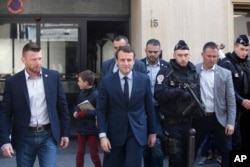 Emmanuel Macron leaves his Paris apartment Monday.