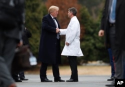 President Donald Trump shakes hands with White House physician Dr. Ronny Jackson as he boards Marine One as he leaves Walter Reed National Military Medical Center in Bethesda, Md., Jan. 12, 2018, after his first medical check-up as president.