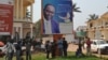 Residentes de Bangui ao pé de um poster do presidente da República Centro Africana, François Bozizé, 28 Dezembro 2012
