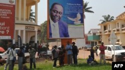 Beberapa orang berdiri di bawah poster Presiden Republik Afrika Tengah, Francois Bozize di Bangui (foto: dok). Kelompok pemberontak Seleka menuntut mundurnya Presiden Bozize.