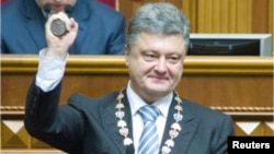 Ukraine's President Petro Poroshenko shows the presidential seal during his inauguration ceremony in the parliament hall in Kyiv, June 7, 2014.