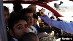 Seorang pekerja medis memeriksa suhu para penumpang di sebuah taksi di tengah kekhawatiran penyebaran wabah virus corona (Covid-19) di Sanaa, Yaman, 9 Mei 2020. (Foto: Reuters)