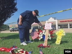 A man pays his respects at an impromptu memorial near the scene of a shooting of four U.S. Marines at an Armed Forces Career Center/National Guard recruitment office in Chattanooga, Tennessee, July 17, 2015. (VOA / S. Behn)