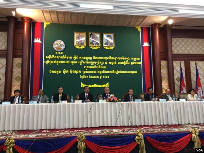 រូបឯកសារ៖ លោក ស៊ិក ប៊ុនហុក (កណ្តាល) ប្រធានគណៈកម្មាធិការជាតិរៀបចំការបោះឆ្នោត (គ.ជ.ប) និងសមាជិកនៃគណៈកម្មាធិការជាតិរៀបចំការបោះឆ្នោត នៅក្នុងសន្និសីទសារព័ត៌មានស្តីពីការបង្ហាញ និងសាកល្បងទឹកថ្នាំសម្រាប់បម្រើឲ្យការបោះឆ្នោត នាថ្ងៃទី១៧ ខែឧសភា ឆ្នាំ២០១៧។ (កាន់ វិច្ឆិកា/VOA)