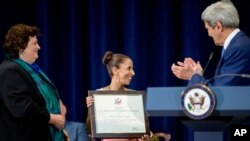 John Kerry and Kari Johnstone applaud as Betty Pedraza Lozano of Colombia, center, is recognized.