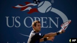 Petenis Perancis Paul-Henri Mathieu, mengembalikan bola ke arah petenis Jerman Tommy Haas dalam putaran pertama kejuaraan tenis terbuka AS "US Open" 2013, 27 Agustus, 2013, di New York. (AP Photo / David Goldman).