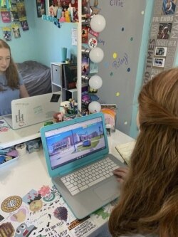 In this April 10, 2020 photo made available by Tami Malloy, Grace Malloy watches a virtual tour of the University of Colorado, while at home in Forest Grove, Oregon.