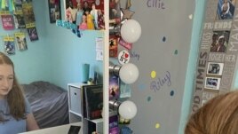 In this April 10, 2020 photo made available by Tami Malloy, Grace Malloy watches a virtual tour of the University of Colorado, while at home in Forest Grove, Oregon.