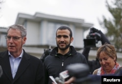 FILE - Lawyer Dennis Edney (left), client Omar Khadr and Patricia Edney meet the media outside their house where Khadr will stay after being released on bail in Edmonton, Alberta, May 7, 2015.