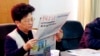 FILE - Yang Xiuzhu reads newspaper during meeting in Wenzhou, Zhejiang province, China, Dec. 29, 2001.